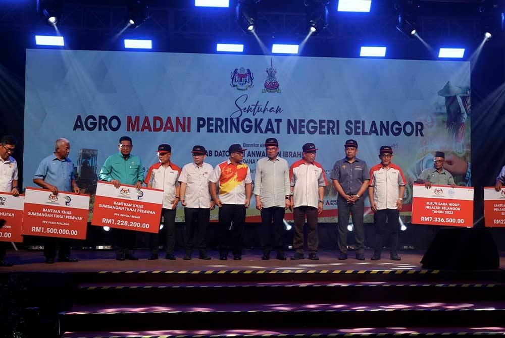 Anwar (tengah) bersama penerima bantuan pada Majlis Program Sentuhan Agro Madani Peringkat Negeri Selangor di Sekinchan, hari ini. Foto Bernama