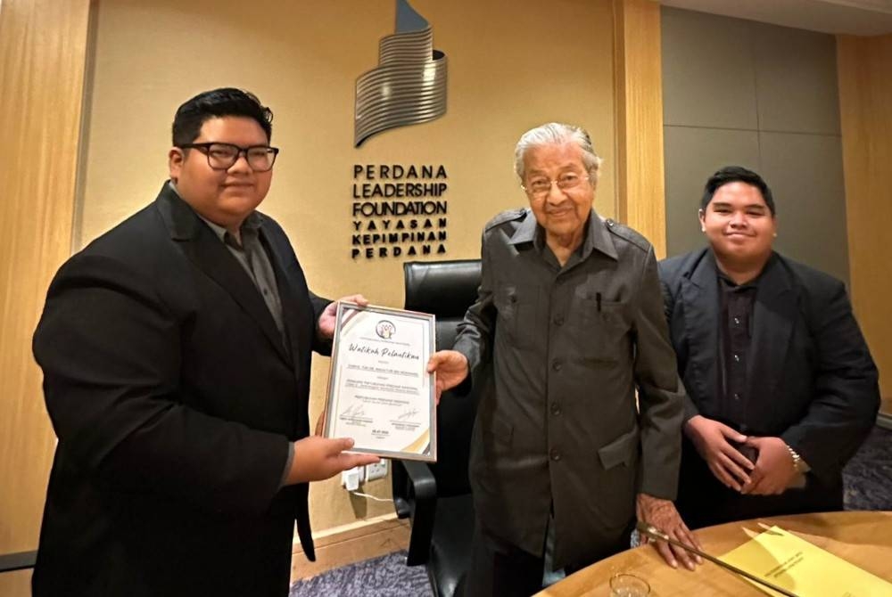 Abdul Hakim (kiri) menyerahkan watikah pelantikan kepada Dr Mahathir sebagai Penasihat dan Penaung PPN di Yayasan Kepimpinan Perdana, Putrajaya pada Isnin.