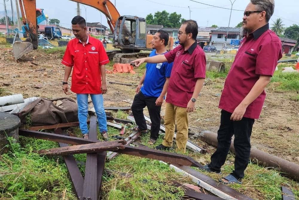 Nik Saiful Adli (tiga dari kiri) melihat surau yang dirobohkan dua hari lalu.