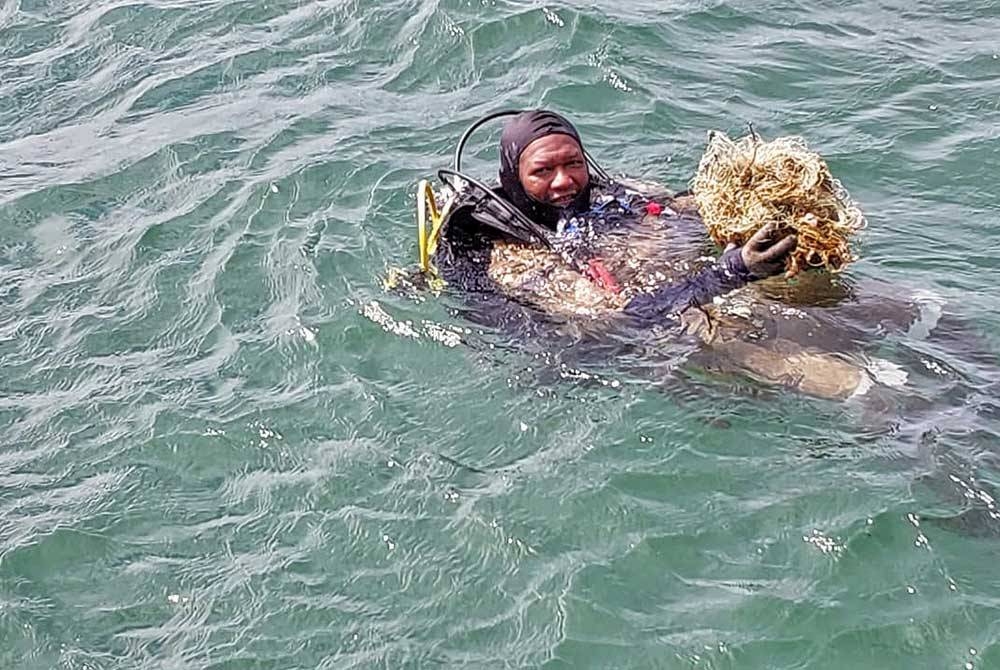 Seorang penyelam menunjukkan &#039;pukat hantu&#039; yang berjaya dibersihkan.