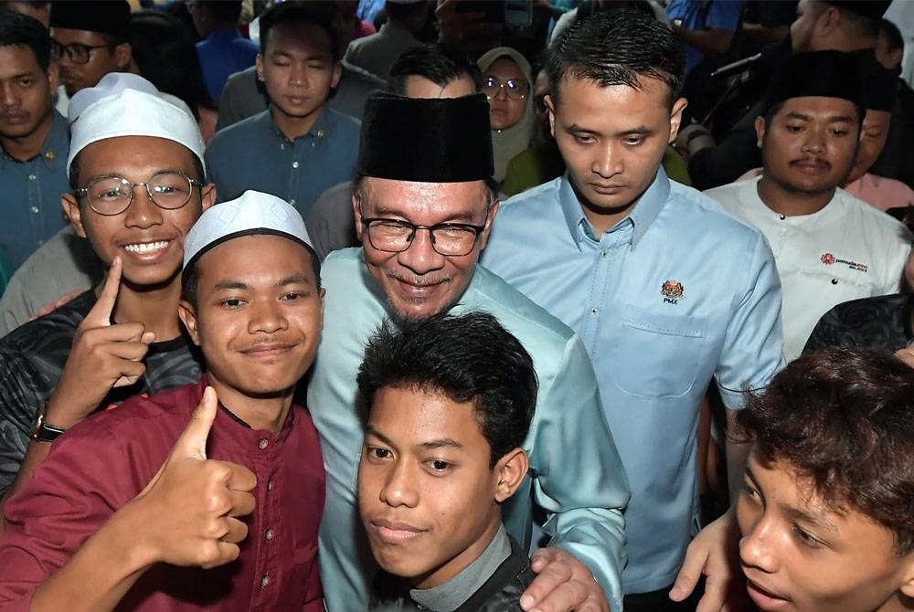 Anwar (tengah) beramah mesra bersama anak muda ketika hadir ke Sambutan Maal Hijrah 1445H Perpaduan Tanjong Karang di Kampung Raja Musa Tanjong Karang pada Rabu. - Foto: Bernama