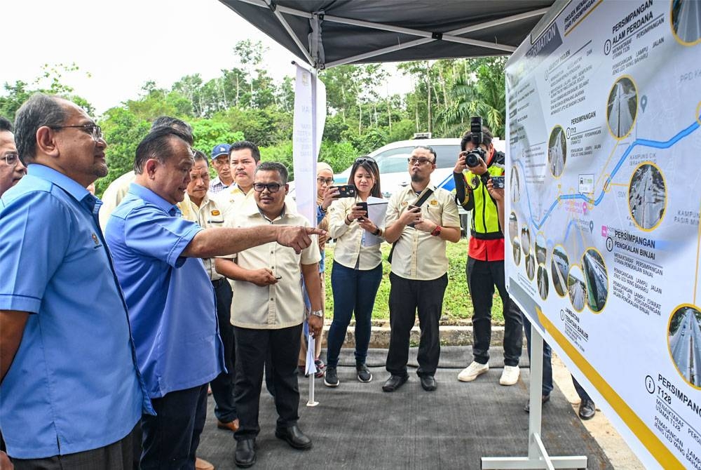 Alexander Nanta Linggi (dua kiri) melihat pelan projek pada Majlis Penyerahan Projek Menaiktaraf Jalan Persekutuan FT237 Chukai dan Penyerahan Sijil Kontraktor Penyiap pada Khamis. - Foto: Bernama