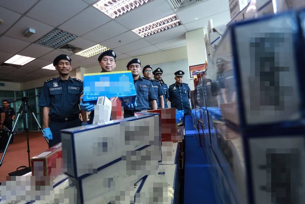 Pun Sian (dua, kiri) menunjukkan antara rampasan rokok seludup di Pelabuhan Klang, Selangor baru-baru ini.