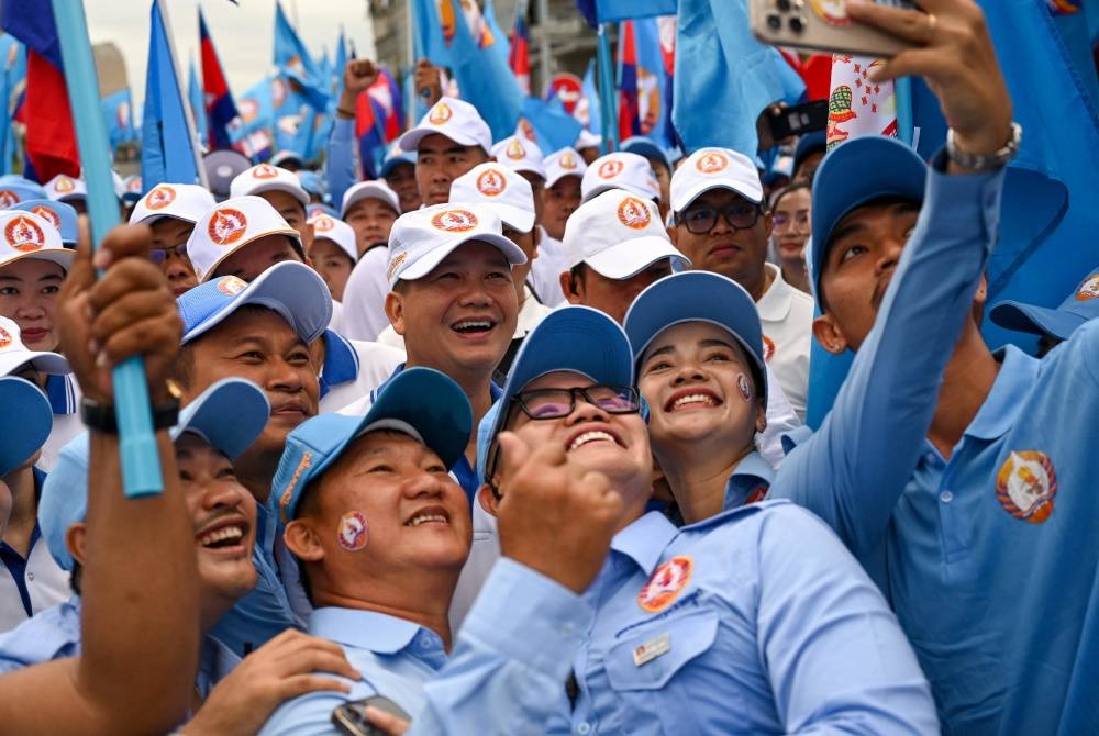 Hun Manet mengambil swafoto dengan penyokong semasa perhimpunan kempen di Phnom Penh. - Foto AFP