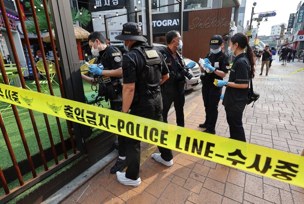 Pegawai polis menyiasat kes amuk lelaki menikam orang ramai di stesen kereta api bawah tanah Sillim, Seoul. - AFP