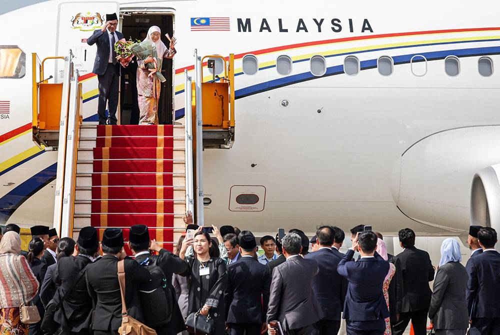 Anwar dan isteri, Wan Azizah melambai tangan sebelum berlepas pulang ke Kuala Lumpur selepas mengakhiri lawatan rasmi dua hari ke Vietnam di Lapangan Antarabangsa Noi Bai. - Foto Bernama