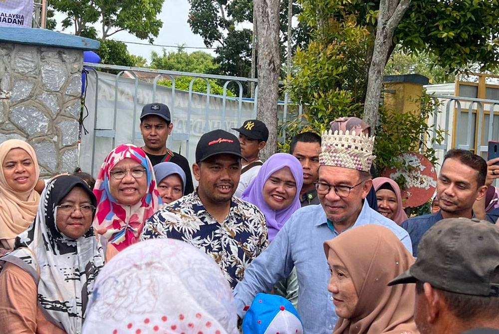 Anwar beramah mesra dengan pengunjung yang hadir pada Majlis Perasmian Mini KUD di Stadium Sungai Besar pada Sabtu.