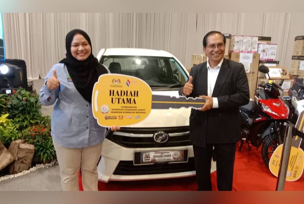 Fazielah Junaidi (kiri) menerima hadiah cabutan bertuah sebuah kereta Perodua Axia.