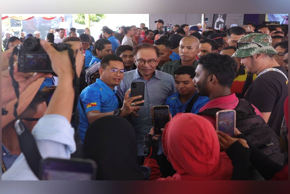 Anwar beramah mesra bersama penghantar makanan selepas sesi Temu Anwar sempena Program Himpunan Rider Madani@Selangor di Laman Majlis Perbandaran Petaling Jaya pada Sabtu. - Foto Bernama