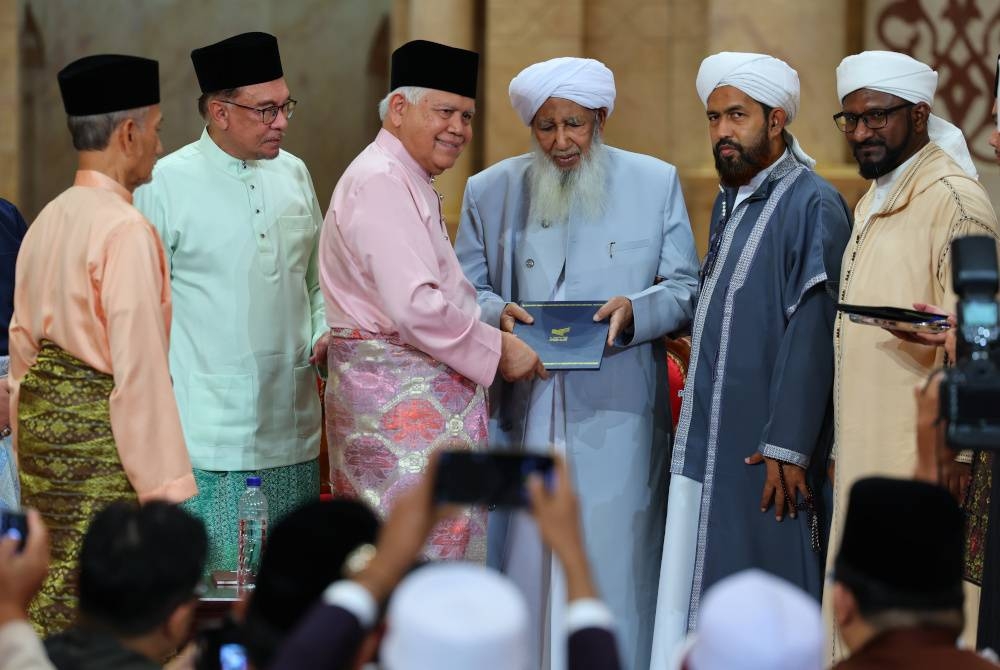 Anwar (dua dari kiri) menyaksikan penyerahan dokumen perjanjian (MOU) antara wakil Kolej Universiti Yayasan Pahang (tiga dari kiri) dengan Universiti Jamia Markaz India diwakili oleh Mufti Besar India, Al-Allamah Sheikh Abu Bakar Ahmad (tiga, kanan) pada Seminar Penghayatan Sahih Al-Bukhari dan Peluncuran Majlis Hadis Sahih Al-Bukhari Peringkat Kebangsaan di Masjid Putra malam Sabtu. - Foto Bernama