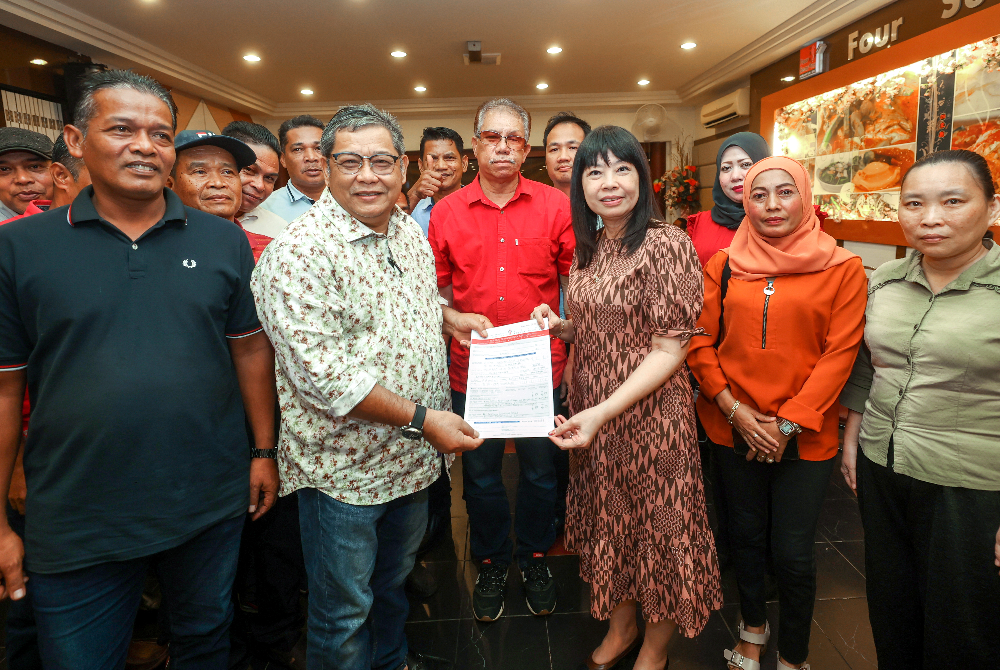 Setiausaha DAP Pulau Pinang, Lim Hui Ying (tiga, kanan) menerima borang keahlian DAP daripada Mohd Zulkifli (dua, kiri). - Foto Bernama