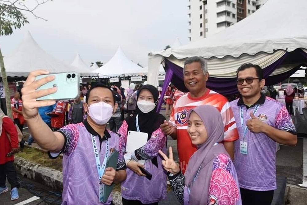 Ahmad (dua dari kanan) merakam gambar ketika menghadiri Program Madani Afiat & One Hour Malaysia Clean Up Peringkat Negeri Terengganu 2023 di Kuala Terengganu, pada Ahad.