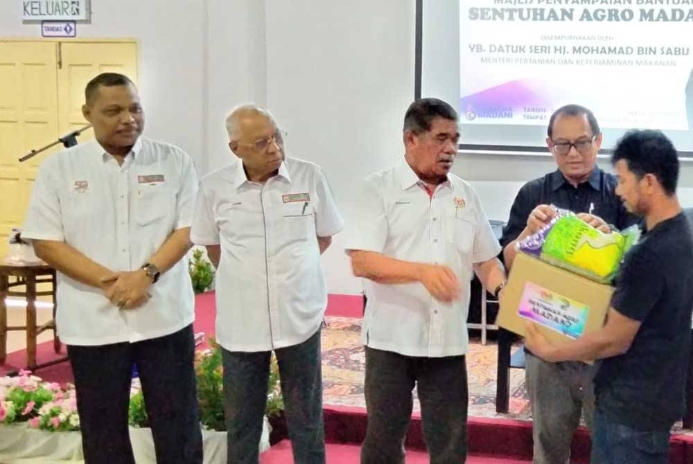 Zamri (dua dari kiri) ketika Majlis Penyampaian Bantuan Sentuhan Agro Madani oleh Menteri Pertanian Dan Keterjaminan Makanan (KPKM), Datuk Seri Muhammad Sabu (tengah) di Institut Pengurusan Peladang, Panji pada Ahad.