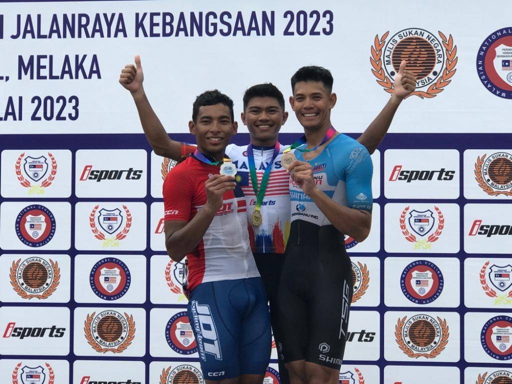 Aiman (tengah) diapit Nur Aiman (kiri) dan Irwandie selepas majlis penyampaian pingat Kejohanan Berbasikal Kebangsaan 2023 di Bukit Katil pada Ahad.