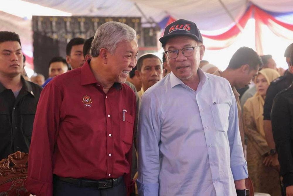 Ahmad Zahid (kiri) bersama Perdana Menteri, Datuk Seri Anwar Ibrahim (kanan) hadir di Gua Musang pada Ahad.