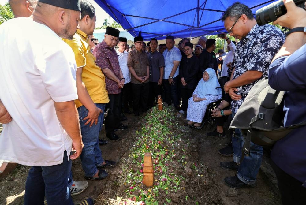 Ahmad Zahid (berdiri tiga dari kiri) menziarahi pusara Allahyarham Salahuddin di Tanah Perkuburan Jalan Sulong, Serkat, Tanjung Piai, Pontian hari ini. - Foto Bernama