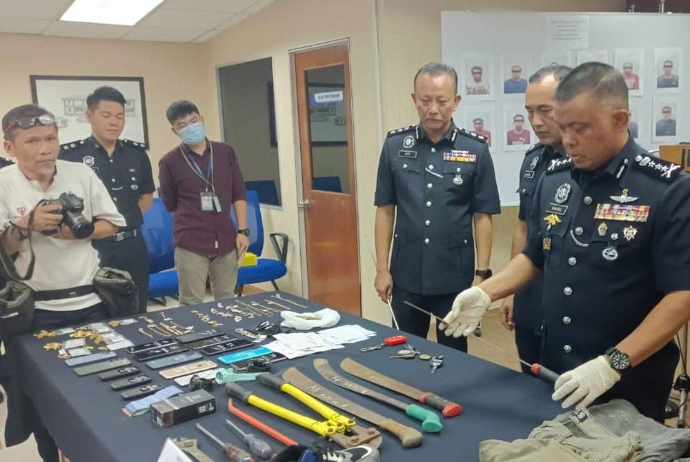 Kamarul Zaman menunjukkan sebilah parang yang digunakan dalam kegiatan pecah rumah, pada sidang akhbar di IPK Johor, Johor Bahru pada Isnin.