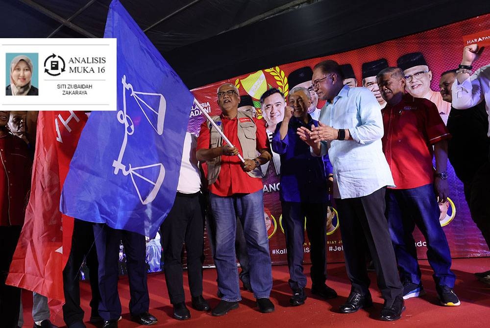 Anwar menyampaikan bendera parti kepada Pengerusi UMNO Kedah, Datuk Seri Mahdzir Khalid dan Naib Presiden Amanah, Datuk Mahfuz Omar semasa gimik Pelancaran Jentera Perpaduan Negeri Kedah di Padang Awam Guar Chempedak baru-baru ini. - Foto Bernama