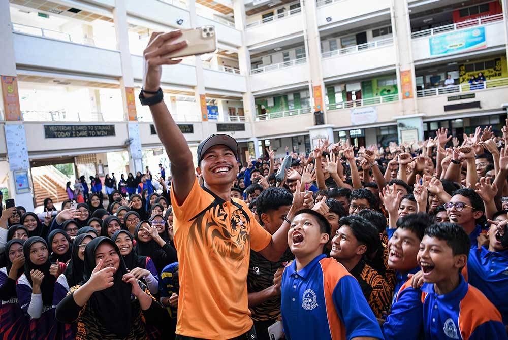 Azeem bergambar dengan sebahagian pelajar selepas menghadiri sesi Meet & Greet bersama atlet olahraga kebangsaan di Sekolah Menengah Kebangsaan (SMK) Presint 8 (1), Putrajaya pada Isnin. - FOTO: BERNAMA