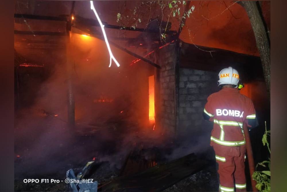 Pasukan bomba memadamkan kebakaran rumah di Kampung Sangkir Kota Belud.