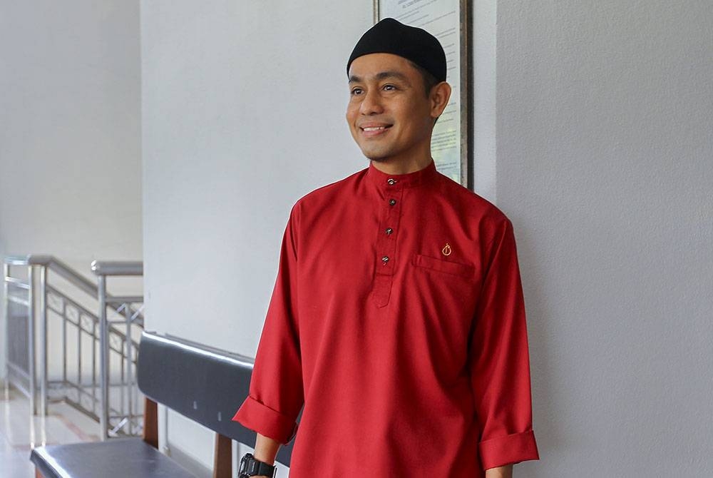 Azman berbaju merah hadir bersama peguamnya di Mahkamah Sesyen pada Rabu.