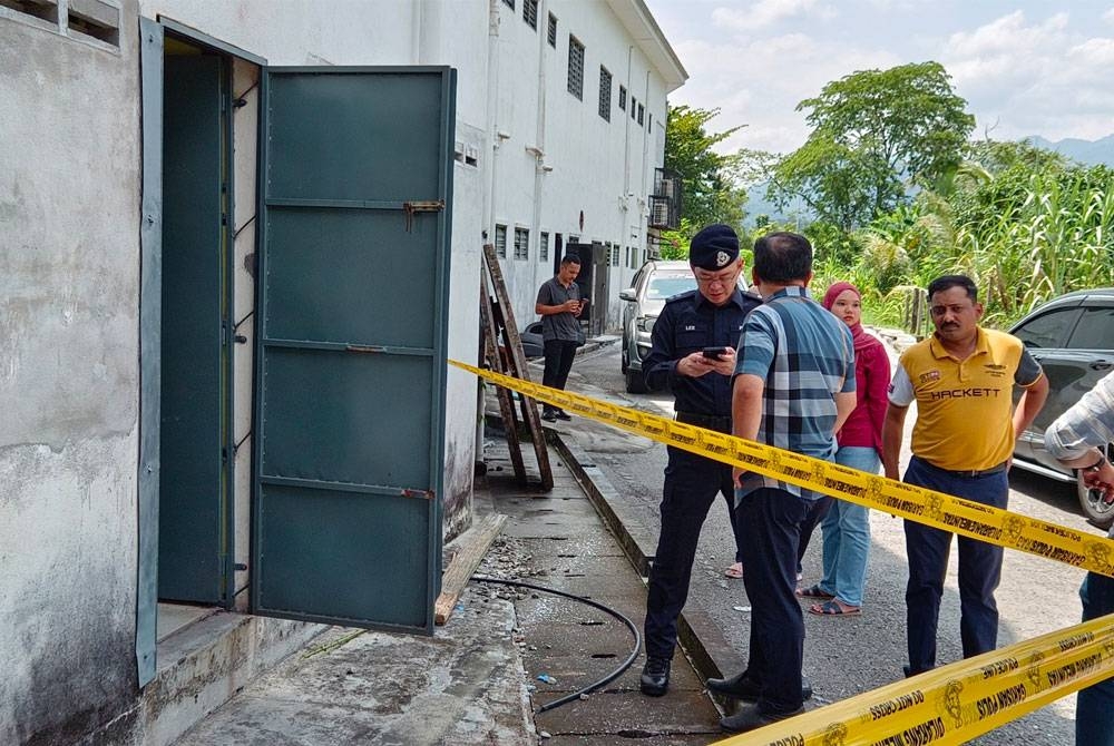 Polis menjalankan pemeriksaan di pintu belakang kedai emas yang dipecah masuk tiga suspek pada Rabu.