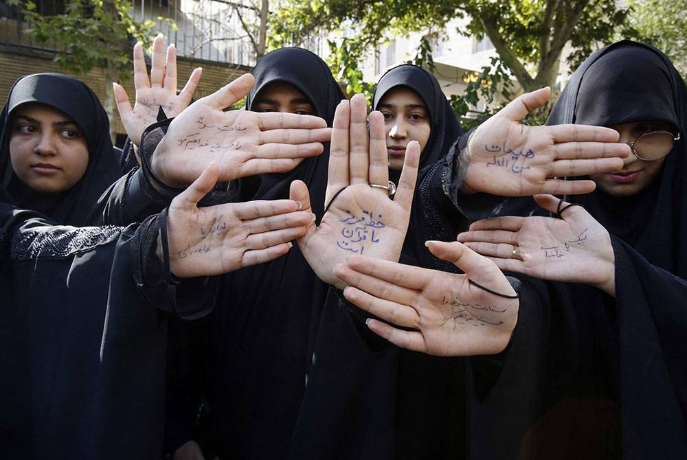 Pelajar Iran menunjukkan slogan ditulis pada tangan semasa demonstrasi mengecam pembakaran al-Quran di Sweden. - Foto AFP