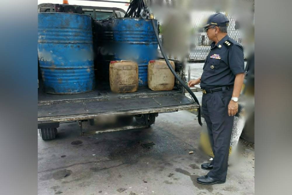 Pegawai KPDN menjalankan pemeriksaan terhadap sebuah lori yang disyaki membuat pembelian minyak diesel bersubsidi tanpa sebarang kebenaran di sebuah stesen minyak di Seri Manjung, Lumut pada Rabu. - Foto ihsan KPDN Perak