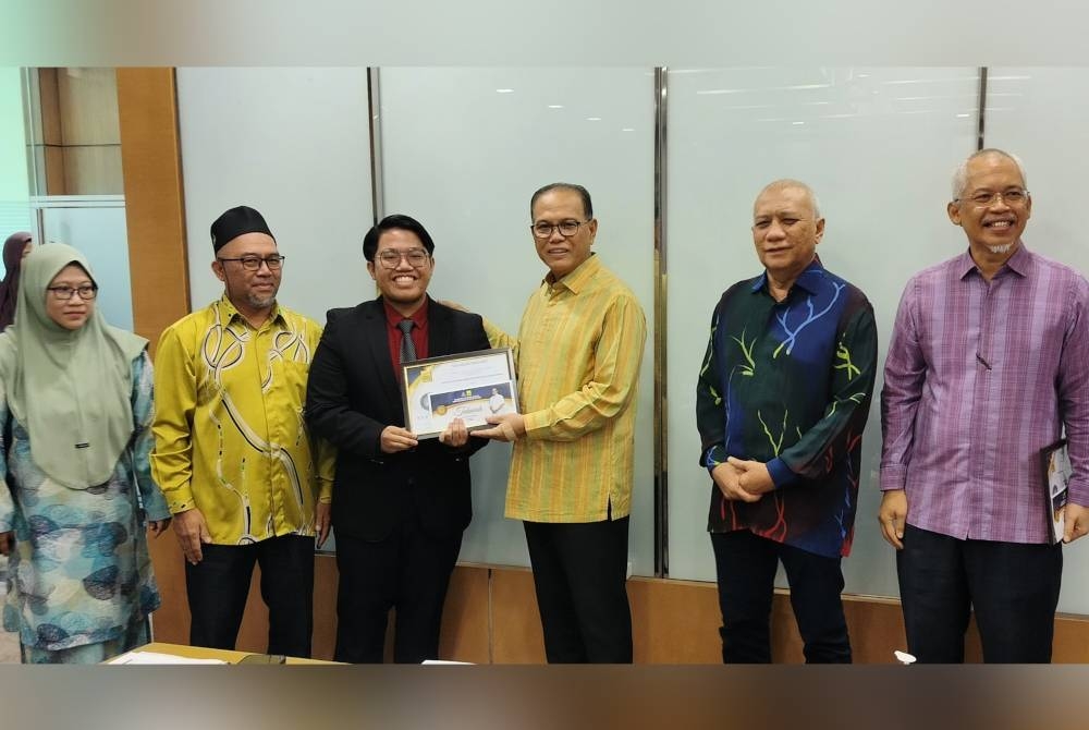 Wan Rosdy menyerahkan anugerah BKMB kepada Nik Hadif Darwisy Mohd Hazaki, salah seorang daripada empat penerima biasiswa itu tahun ini pada Majlis Kecemerlangan Pendidikan Yayasan Pahang di sini pada Khamis.