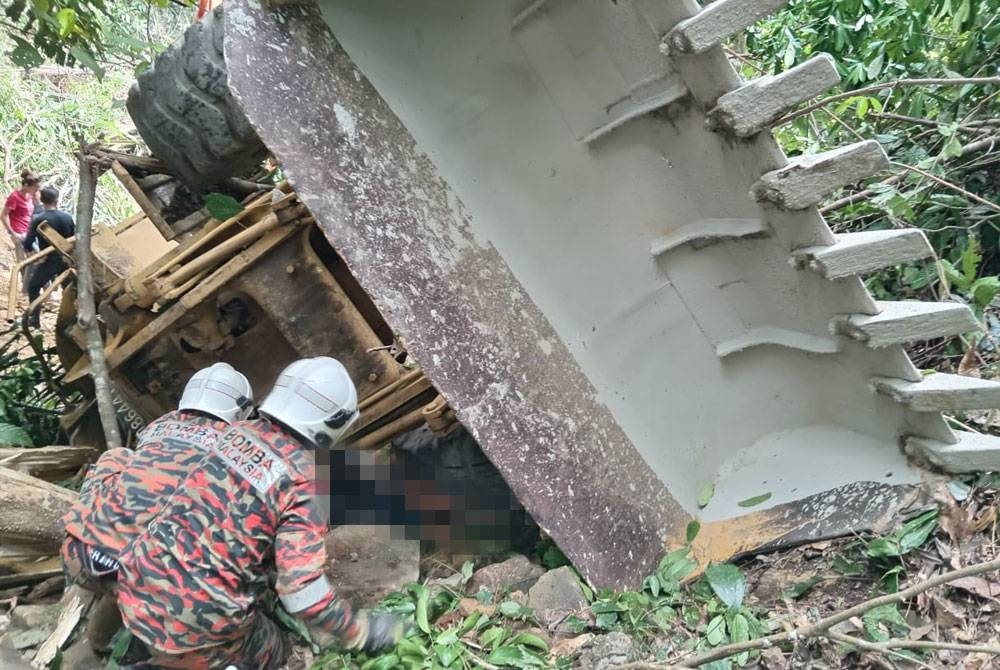 Pasukan bomba cuba mengeluarkan mangsa yang tersepit pada jengkaut di kawasan ladang kelapa sawit di Kampung Rosob, Pitas.