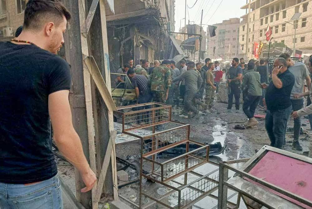 Orang ramai berkumpul di lokasi kejadian letupan di bandar al-Sayeda Zainab, Damsyik. - Foto AFP