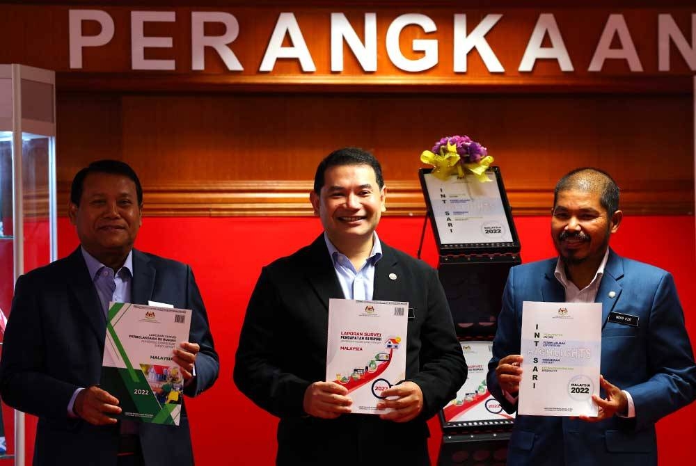 Rafizi (tengah) menunjukkan buku laporan Survei Pendapatan Isi Rumah Tahun 2022 pada Majlis Pengumuman Penemuan Survei Pendapatan dan Perbelanjaan Isi Rumah 2022 di Jabatan Perangkaan Malaysia pada Jumaat. - Foto Bernama