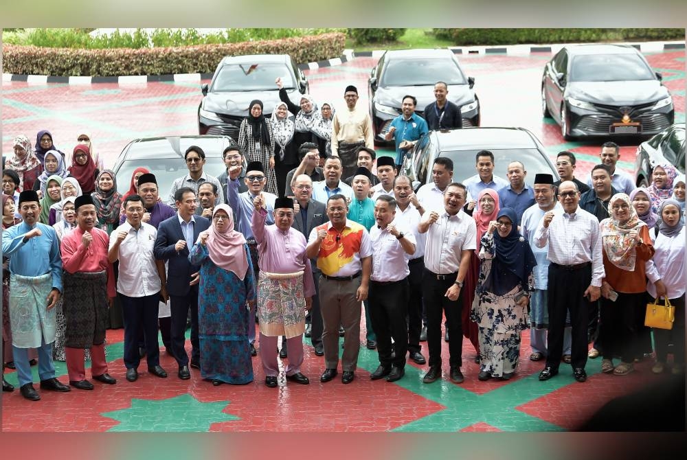 Amirudin (tengah) bergambar bersama kakitangan Kerajaan Negeri Selangor selepas majlis penyerahan kenderaan rasmi di Dataran Setiausaha Kerajaan Negeri pada Jumaat. - Foto Bernama