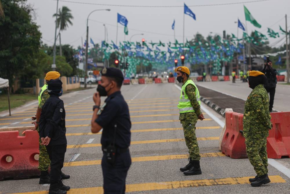 Anggota PDRM dibantu anggota Jabatan Sukarelawan Malaysia (Rela) membuat kawalan ketat di jalan utama memasuki Pusat Penamaan Calon PRN bagi DUN N.30 Kijal di Dewan Sivil Kijal pada Sabtu. - Foto Bernama