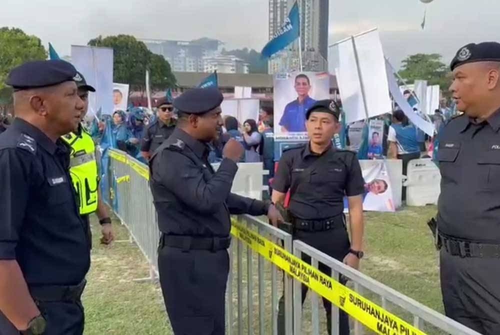 Hussein (dua, kiri) membuat pemantauan di pusat penamaan calon PRN di SMK Sungai Pusu, Gombak pada Sabtu.