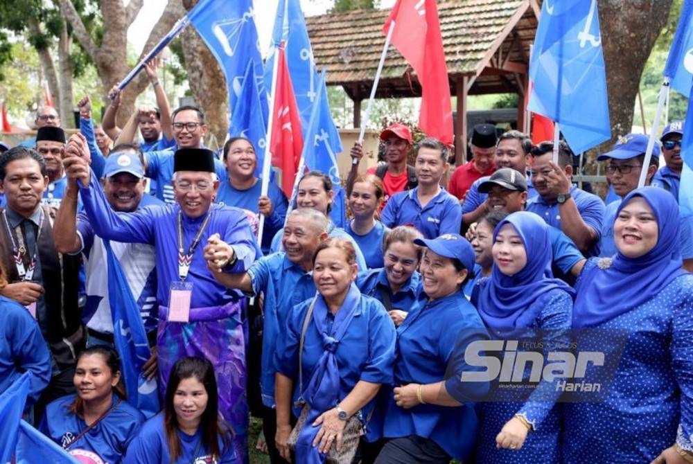 Mahdzir (tiga dari kiri) beramah mesra dengan penyokong BN dan PH yang mengiringi beliau ke pusat penamaan calon pada Sabtu.