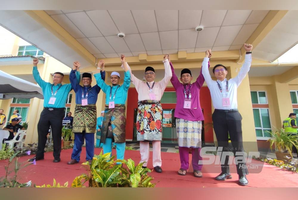 Mahfuz (tiga dari kanan) dan Radhi (tiga dari kiri) bersama calon Suka Menanti dan Kota Darulaman mengangkat tangan beramai-ramai selepas diumumkan sebagai calon di Pusat Penamaan Calon DUN di Kompleks Belia dan Sukan Negeri Kedah, di Alor Setar, pada Sabtu.