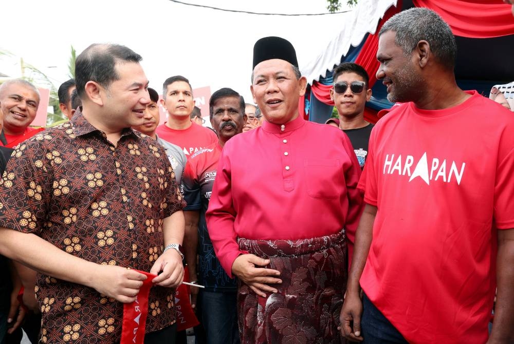 Aminuddin (tengah) beramah mesra dengan Timbalan Presiden PKR, Rafizi Ramli (kiri) pada proses penamaan calon di Pusat Penamaan Calon Dewan Komuniti Coral Height pada Sabtu.- Foto Bernama