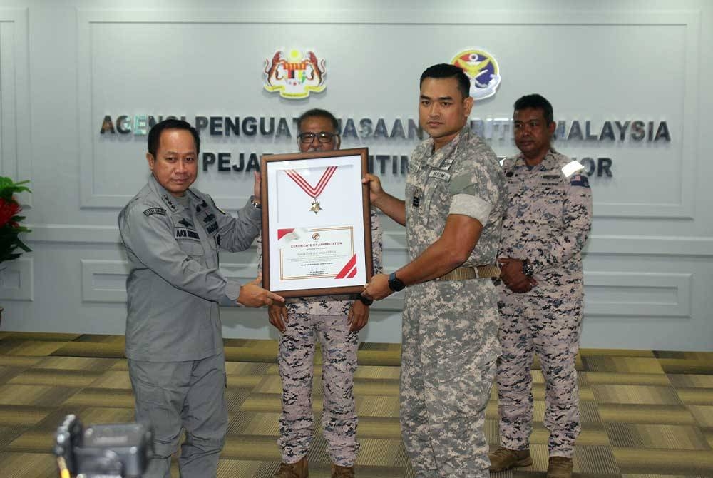 Aan Kurnia (kiri) menyampaikan surat/sijil penghargaan kepada Maritim Malaysia yang diwakili Komander (M) Syuzefril Mat Noor. - Foto: Maritim Johor