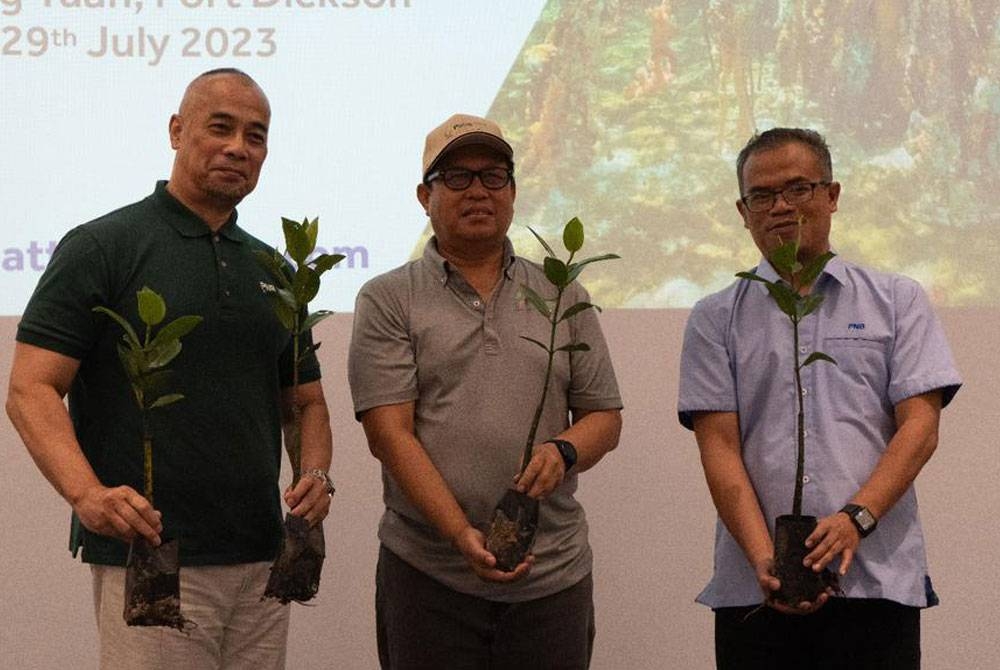 Dari kiri; Ron Hasni Yusoff dan Zailani Ali (tengah) bergambar pada program pembersihan pantai dan penanaman pokok bakau' di Tanjung Tuan, Port Dickson.