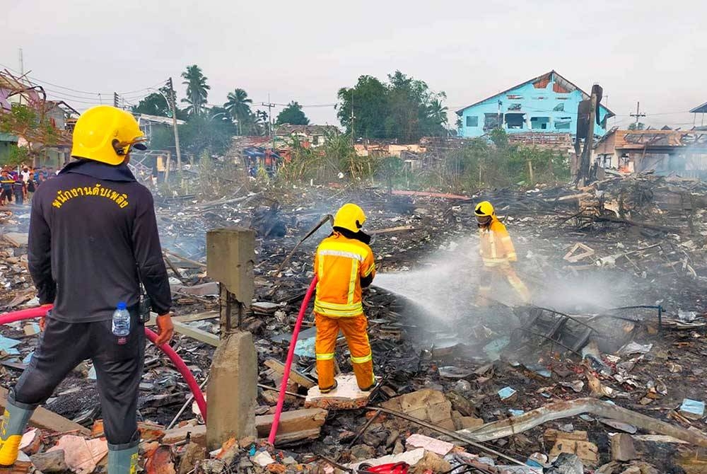 Anggota bomba dan penyelamat Thailand memadamkan kebakaran yang berlaku dalam kejadian letupan di gudang mercun dan piroteknik di Narathiwat, Thailand pada petang Sabtu. - Foto EPA