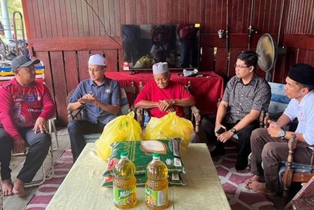 Mohd Fared (dua dari kiri) ketika melawat kediaman sementara mangsa kebakaran di Muar pada Sabtu. - Foto Bernama