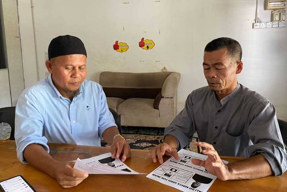 Che Harun (kiri) berbincang mengenai strategi kempen dengan penyokongnya di Lubuk Kawah pada Ahad.