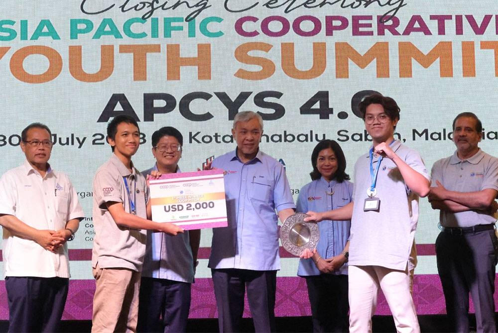 Ahmad Zahid diiringi Ewon menyampaikan hadiah kemenangan tempat pertama kepada peserta Indonesia pada majlis penutupan Asia Pacific Cooperative Youth Summit (APCYS) 4.0 hari ini. - Foto Bernama