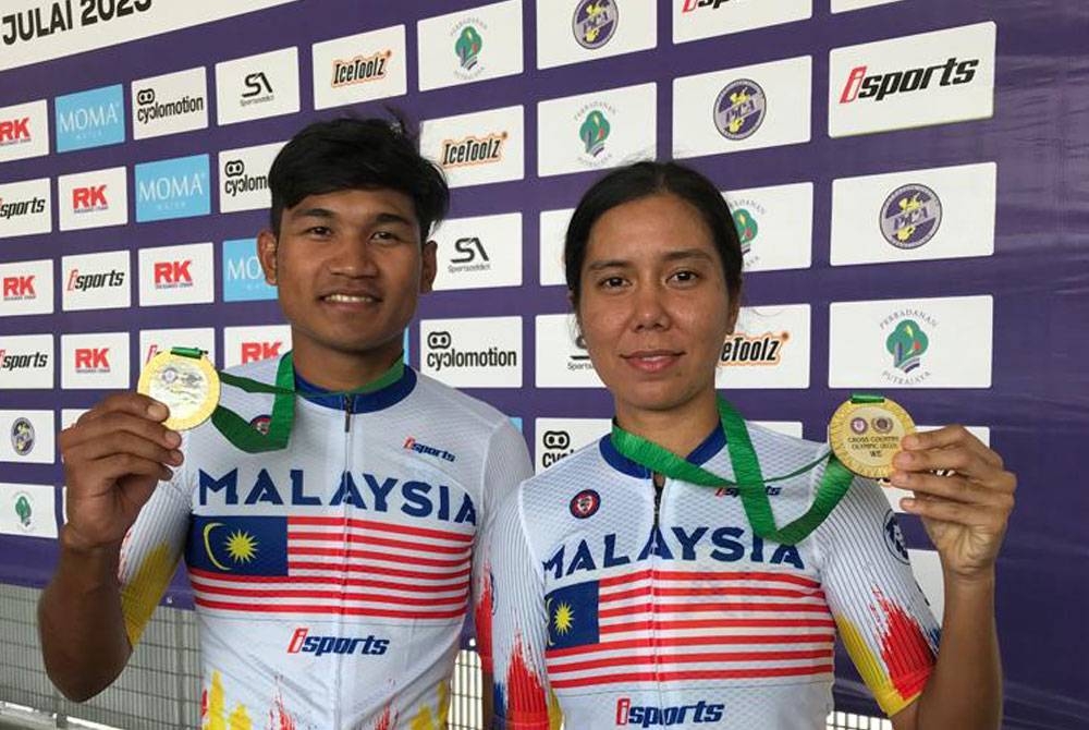 Syazrin (kiri) dan Nur Assyira menunjukkan pingat emas yang dimenangi mereka dalam acara XCO Kejohanan MTB Kebangsaan 2023 di Taman Cabaran, Putrajaya pada Ahad.