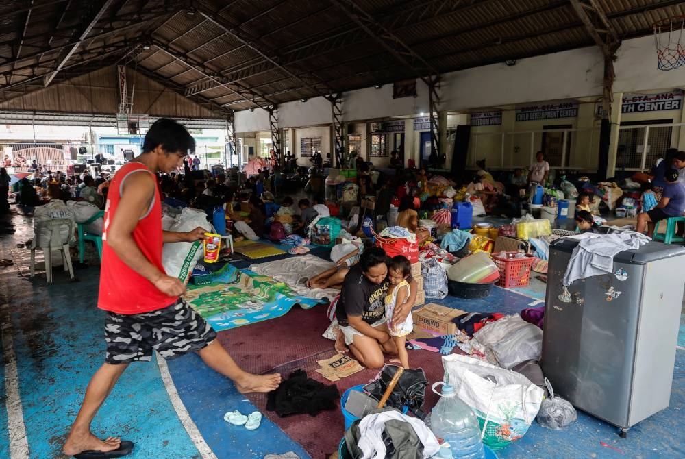 Penduduk berteduh di pusat pemindahan keluarga yang terjejas akibat banjir akibat kesan taufan Doksuri di kampung San Mateo, wilayah Rizal, timur laut Manila, Filipina. - Foto EPA