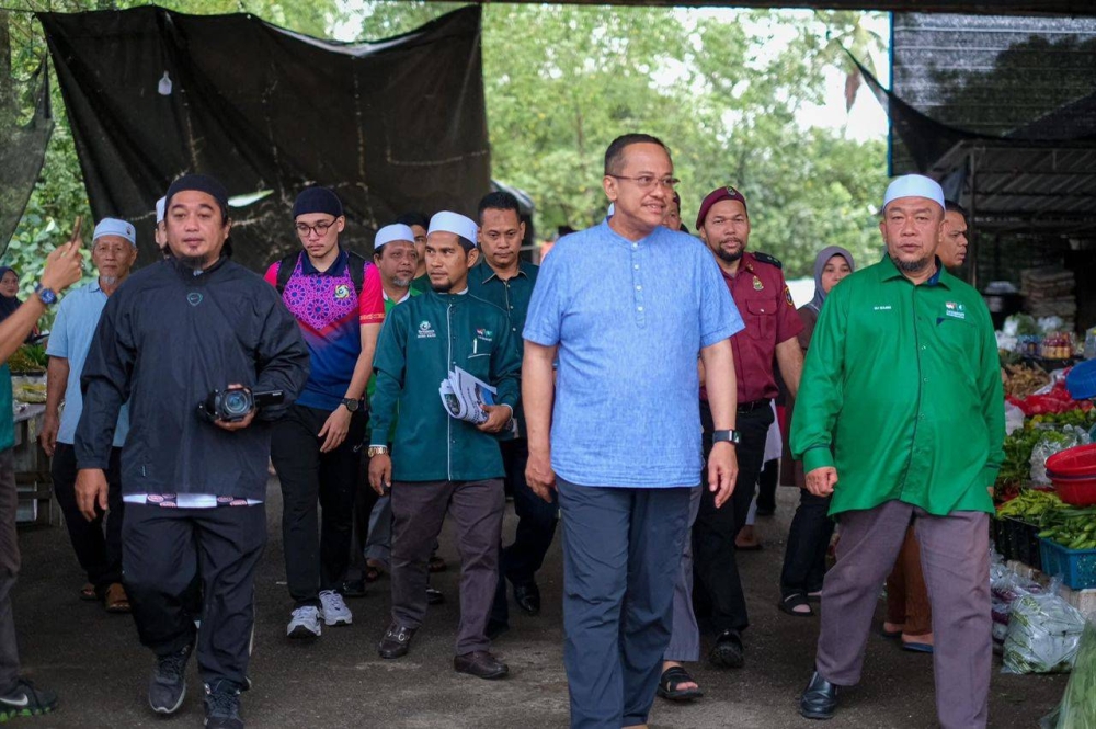 Azbi (kanan) mengiringi Ahmad Samsuri meninjau Pasar Borong Kampung Lampu, di sini pada Isnin.