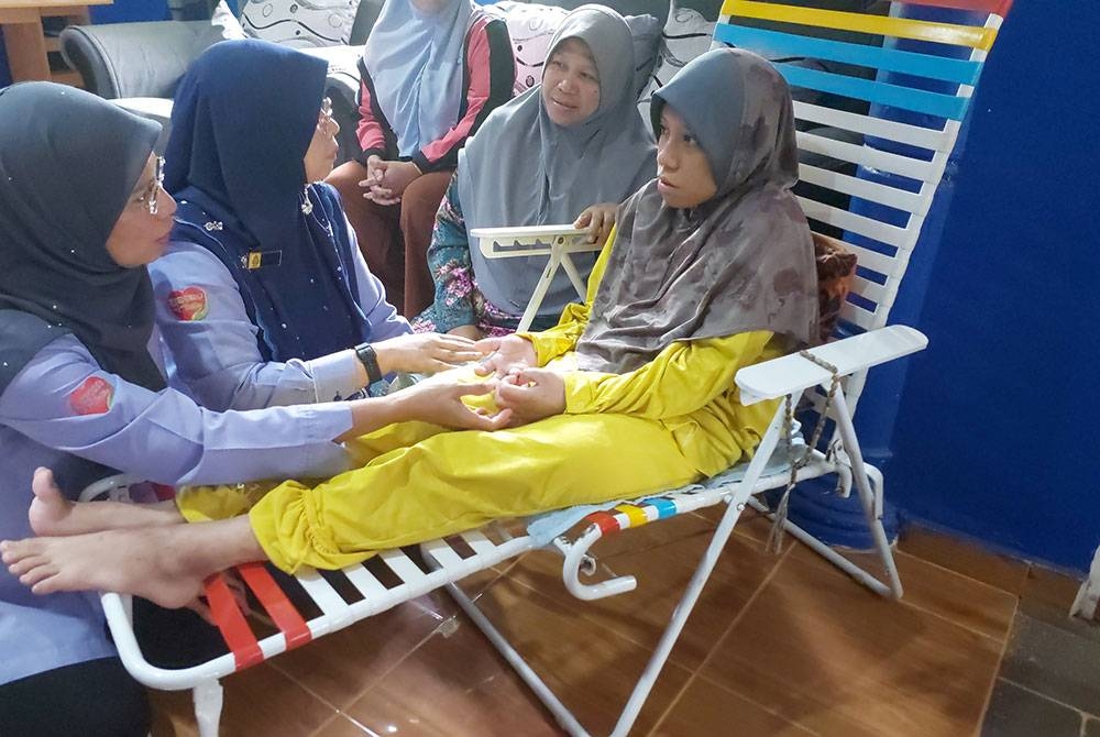 Rosmasita (kiri) bersama Farihah (dua dari kiri) melawat waris keluarga mangsa kemalangan maut di Felda Belara pada Isnin.