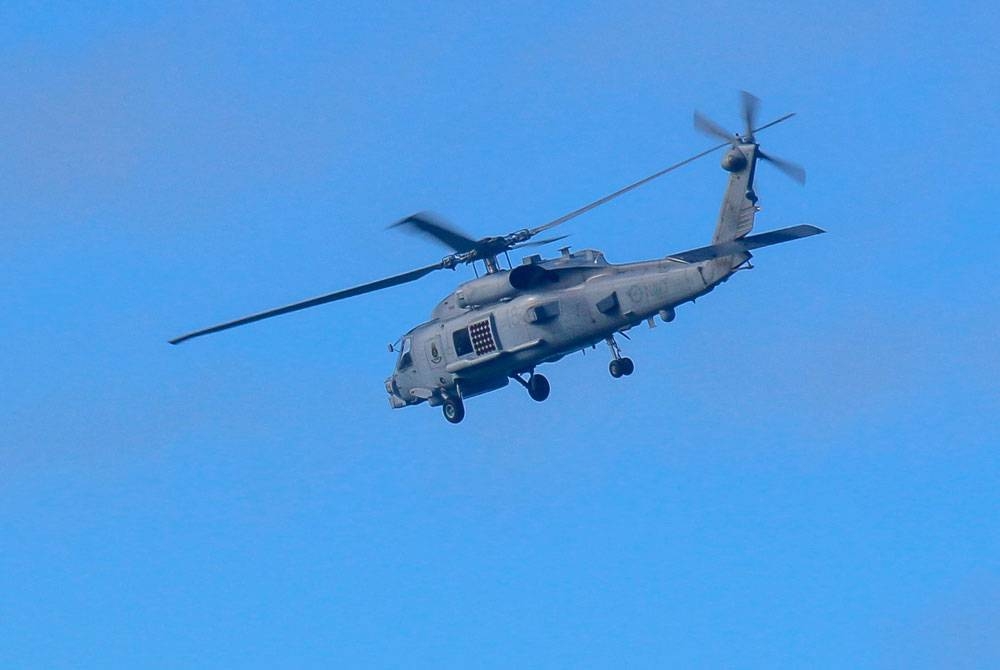 Sebuah helikopter Tentera Laut Diraja Australia menjalankan operasi mencari dan menyelamat di sekitar Pulau Lindeman, Queensland. - Foto AFP