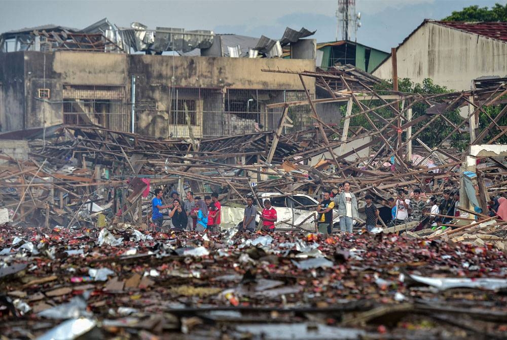 Orang ramai melihat kesan rumah yang musnah selepas gudang mercun meletup di wilayah Narathiwat di selatan Thailand pada 29 Julai lalu. - Foto AFP